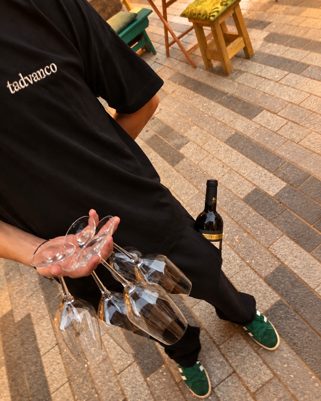 A server carrying wine and a stack of glasses