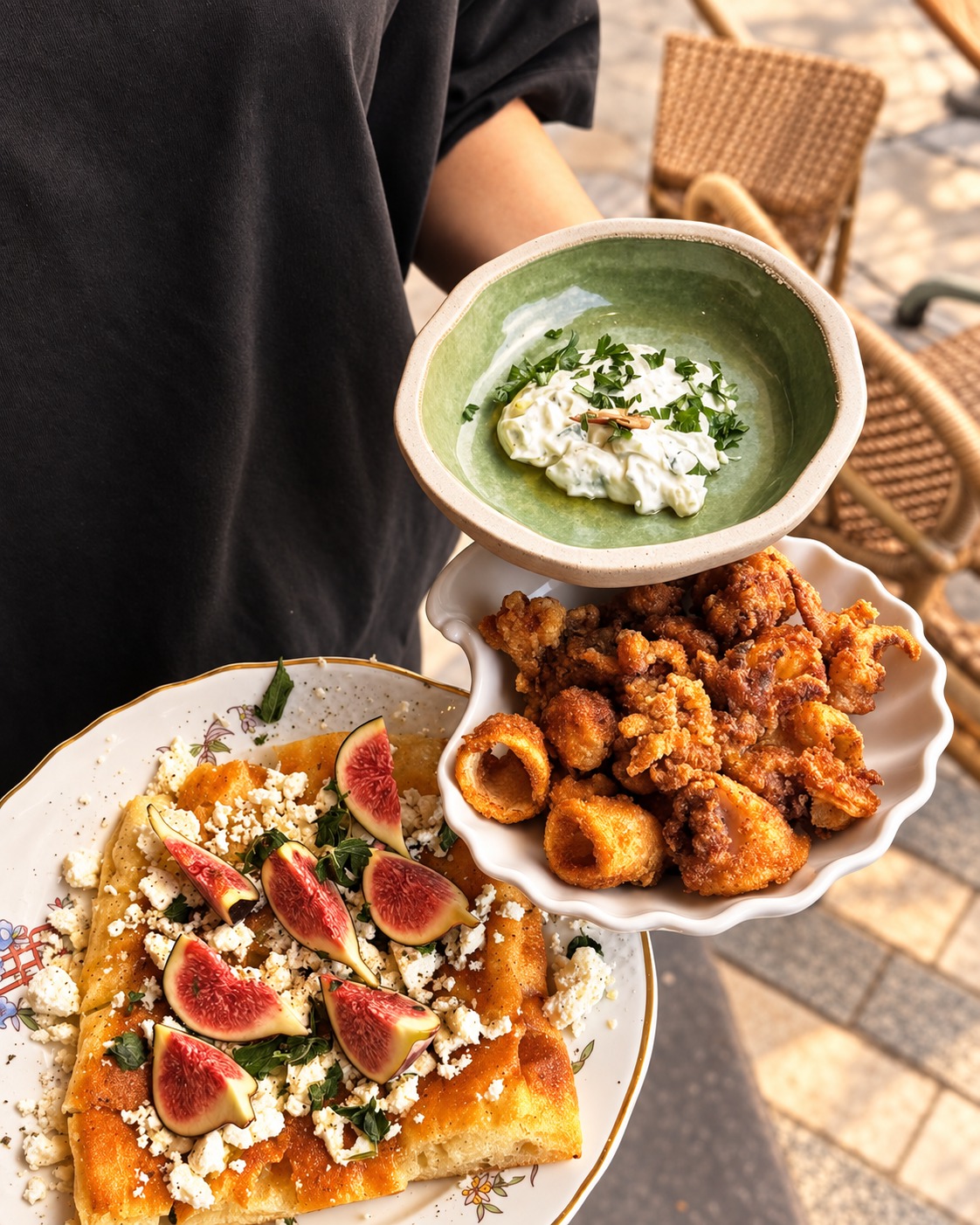 Plates of figs and fried bites held up to share